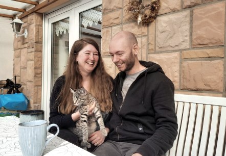Julia und Helge mit Katze auf dem sonnigen Balkon, © Zukunftsinitiative Eifel Julia und Helge mit Katze auf dem sonnigen Balkon, © Zukunftsinitiative Eifel