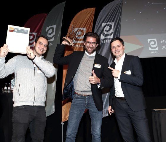Daniel Pfennig (Mitte) freut sich über den EIFEL Award Digitalisierung 2024, © Eifel Tourismus/Stephan Garcon Daniel Pfennig (Mitte) freut sich über den EIFEL Award Digitalisierung 2024, © Eifel Tourismus/Stephan Garcon