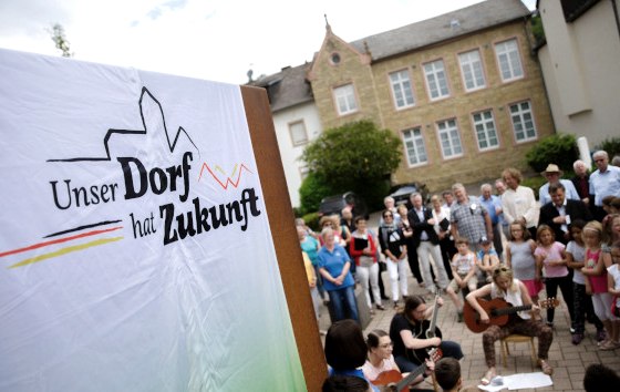 Bettingen im Bitburger Land ist mit aktuell 1.098 Einwohnern das größte Dorf im Westen der Verbandsgemeinde mit Grundzentrumsfunktion. Der Ort verfügt über eine sehr gute Infrastruktur: KiTA, Schule, Sportanlagen, Bürgerhalle, Jugendraum, Dienstleister, Ärzte, Handel und Gewerbe, sowie Landwirtschaft und Gastronomie sind vorhanden. Im Ort besteht eine Pflegeeinrichtung mit 48 Pflegeplätzen. Leitsatz für Bettingen: Gute Infrastruktur erhalten und weiterentwickeln. Gemeinsam Altes bewahren und Neues wagen., © BMEL/Photothek Bettingen im Bitburger Land ist mit aktuell 1.098 Einwohnern das größte Dorf im Westen der Verbandsgemeinde mit Grundzentrumsfunktion. Der Ort verfügt über eine sehr gute Infrastruktur: KiTA, Schule, Sportanlagen, Bürgerhalle, Jugendraum, Dienstleister, Ärzte, Handel und Gewerbe, sowie Landwirtschaft und Gastronomie sind vorhanden. Im Ort besteht eine Pflegeeinrichtung mit 48 Pflegeplätzen. Leitsatz für Bettingen: Gute Infrastruktur erhalten und weiterentwickeln. Gemeinsam Altes bewahren und Neues wagen., © BMEL/Photothek