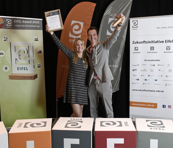 Yvonne Vilela und Malte Tack (Gesch&auml;ftsf&uuml;hrer Vulkan Brauerei) freuen sich &uuml;ber den EIFEL Award 2025, &copy; Eifel Tourismus/Petra Grebe