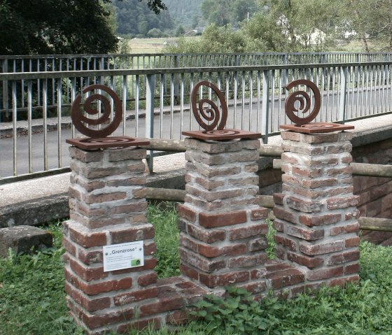 2016 stellte Thomas Rother &bdquo;Grenzrosen&ldquo; im deutsch-belgisch-luxemburgischen Grenzgebiet auf. Hier am Br&uuml;ckenplatz an der Our unterhalb von Welchenhausen., &copy; Eifel hautnah, Stefan Lieser