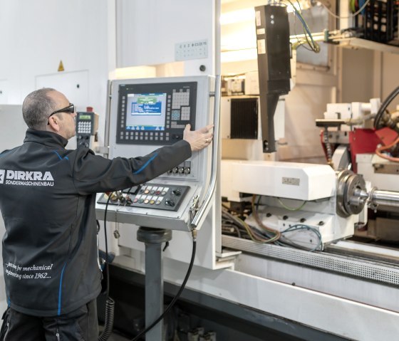 Ein Mitarbeiter an der Maschinensteuerung, © DIRKRA Group