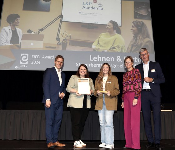 Eva Klein und Eléna Molitor haben am 19.11.2024 bei der feierlichen Preisverleihung in der Bitburger Stadthalle den „Eifel Award 2024“ für Lehnen &amp; Partner entgegengenommen, © Eifel Tourismus GmbH