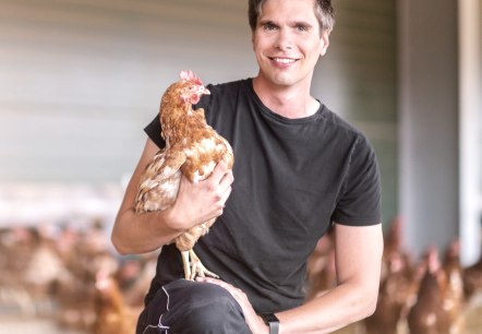 Ren&eacute; Esser mit einem Huhn vom Hof, &copy; Familie Eich